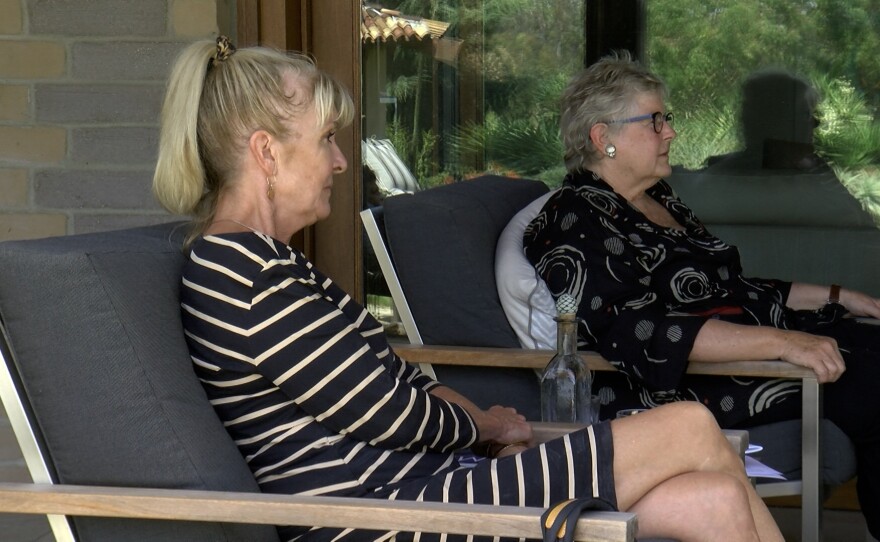 Janet Lawless-Christ (left) and Mary Bills sit and talk in Bill's garden, August 11, 2021. 