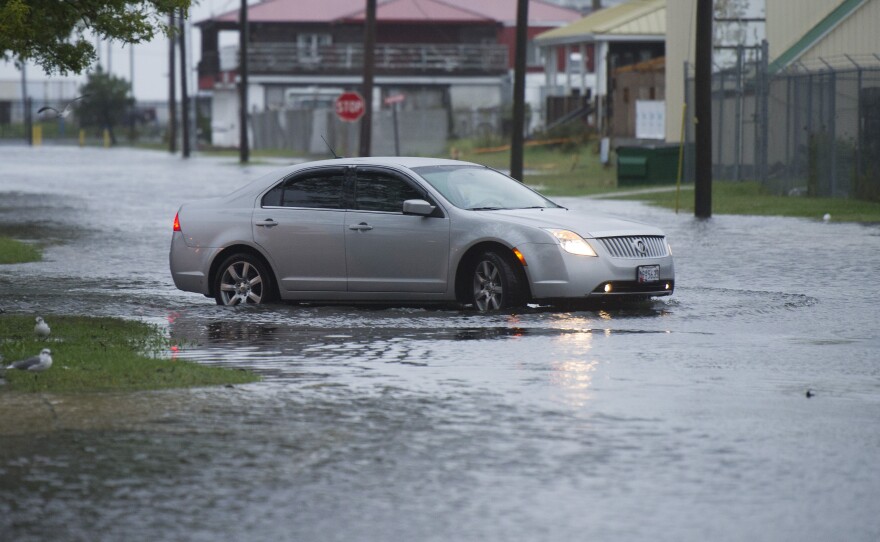 A car drives on flooded Broadway Street in Crisfield, Md., on the Chesapeake Bay, early Sunday.