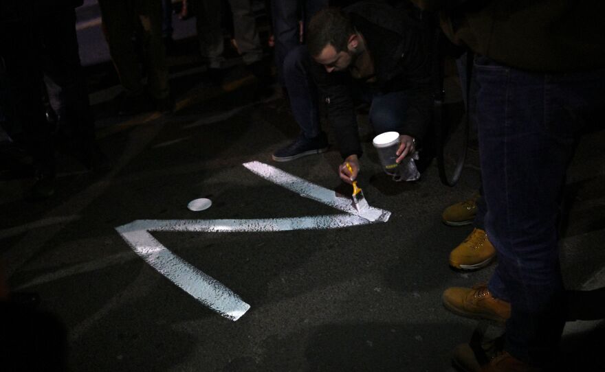 A protester paints the "Z" sign on March 4 on a street in Belgrade, in reference to Russian tanks marked with the letter, during a rally organized by Serbian right-wing organizations in support of the Russian invasion of Ukraine.