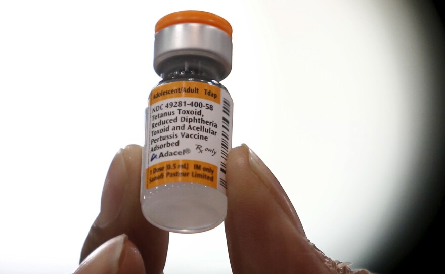 A nurse holds a tetanus, diphtheria and whooping cough vaccine in 2016. Physician Judith Guzman-Cottrill tells NPR that she has met many families who hesitate to give their children vaccines.