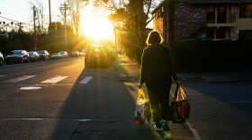 A woman carries reusable shopping bags to her car on Monday, March 16, 2026, in Portland, Ore.