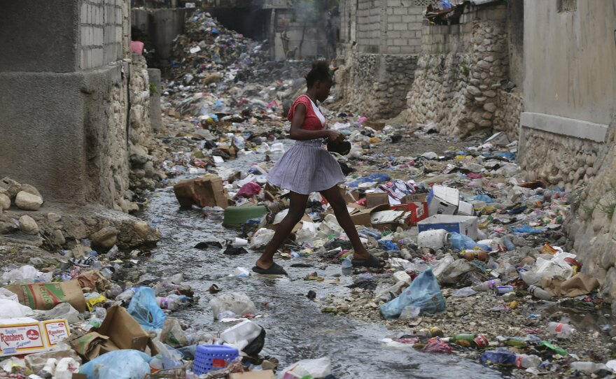 A girl walks through a ravine filled with garbage in Port-au-Prince, Haiti, on July 13.