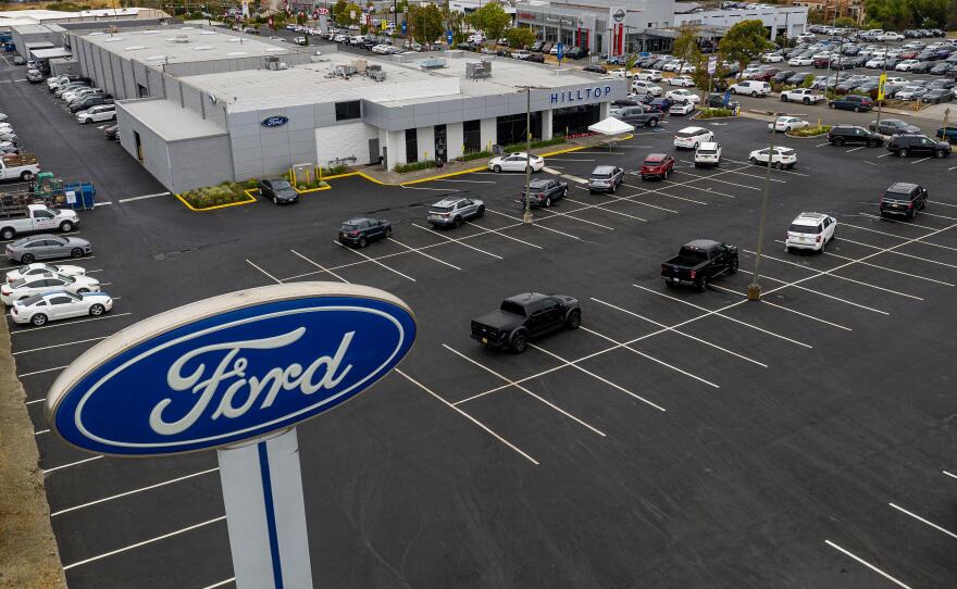 Vehicles sit in a nearly empty lot at a car dealership in Richmond, Calif., on July 1. The global semiconductor shortage has hobbled auto production worldwide, making it difficult to find a car to buy.