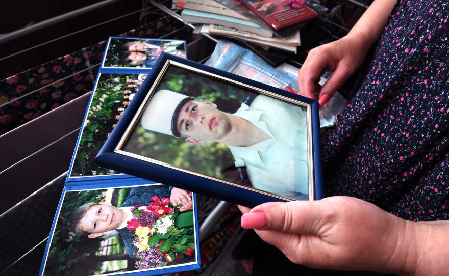 Oksana holds a photo of Oleksandr in his French Foreign Legion uniform.