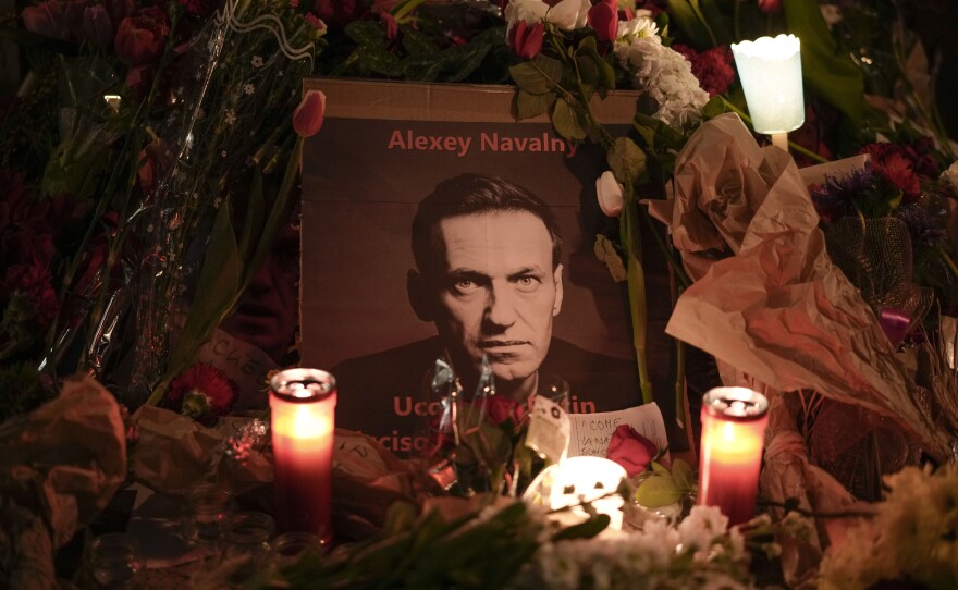 Flowers and candles are laid around a photo of Russian opposition leader Alexei Navalny in Italy.