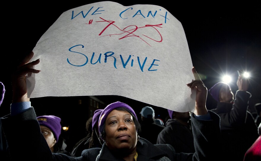 Darlene Handy of Baltimore holds up a banner at a rally supporting a pay measure in Maryland. More than 20 states have raised minimum pay rates above the federal level.