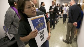 Teamster member Rocio Mejia, a supporter of a proposal to raise the state's minimum wage, joins others outside the Assembly Chambers calling for Assembly members to approve the measure in Sacramento, March 31, 2016.