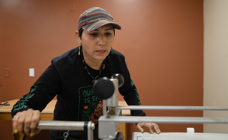 Irie Zepeda of Por La Mano Press is shown demonstrating a pinwheel printing press at the Chicano Park Museum and Cultural Center on Oct. 7, 2025