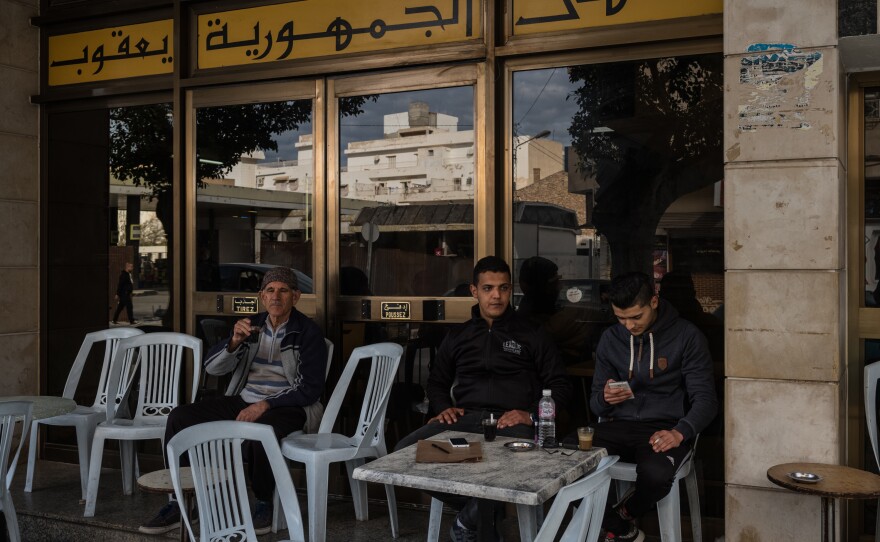 Ahmed Ferjeni (center), 25, sits at a cafe with a friend in Sousse, after going to the employment agency to try and apply for a job. Ahmed trained as a mechanical engineer but has had trouble finding a job in his field.