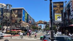 People walk around the Gaslamp District in downtown San Diego, where buildings are dressed up for Comic-Con on July 22, 2025.