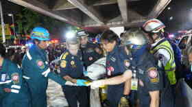 Rescuers carry the body of a victim of a fire in Bangkok, Thailand, Monday, July 13, 2026.