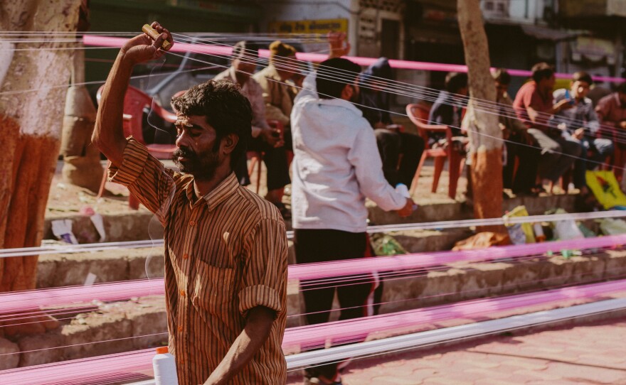 Bright kite strings stretch along a road in Gujarat.