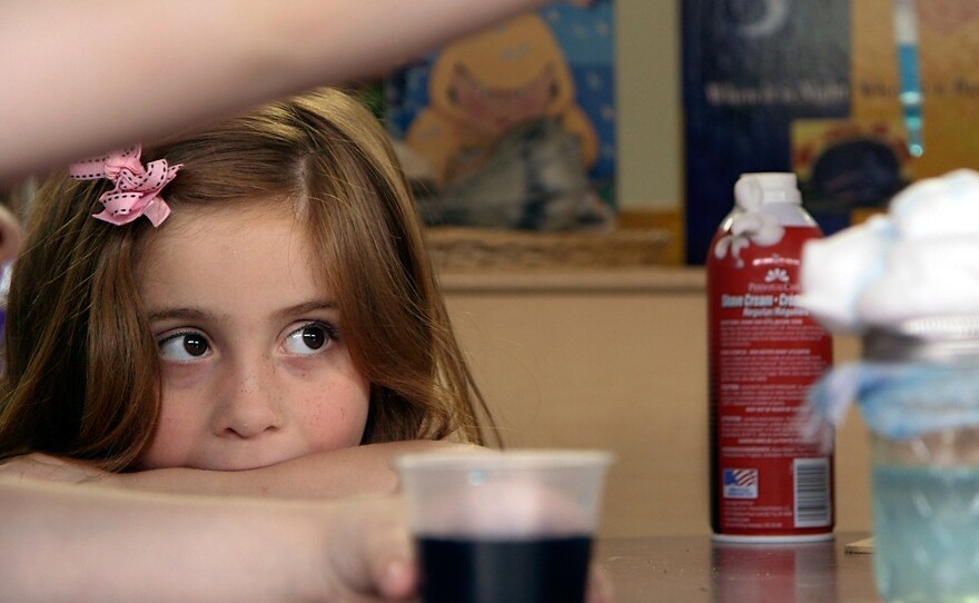 Preschool student Stormy Frazier watches an experiment unfold in Nikki Jones' classroom.