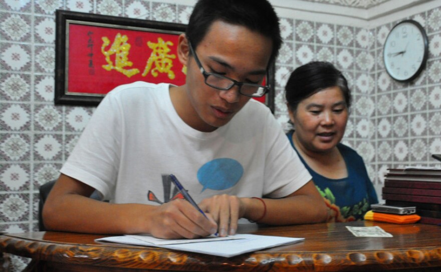 Dai Songxian (right) and her son,  Alex, take a food order. They run the only remaining Chinese restaurant in  Tripoli, as fighting has caused other foreigners to flee.