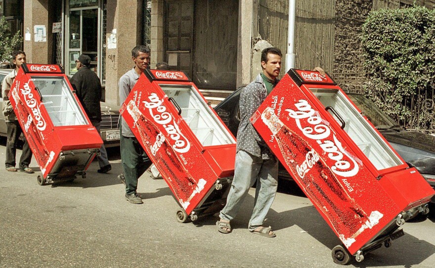 Egyptian workers push Coca-Cola refrigerators through a Cairo street in 2000.