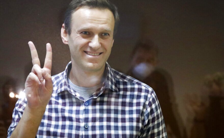 Russian opposition leader Alexei Navalny gestures as he stands in a cage in the Babuskinsky District Court in Moscow, Russia, Saturday, Feb. 20, 2021.