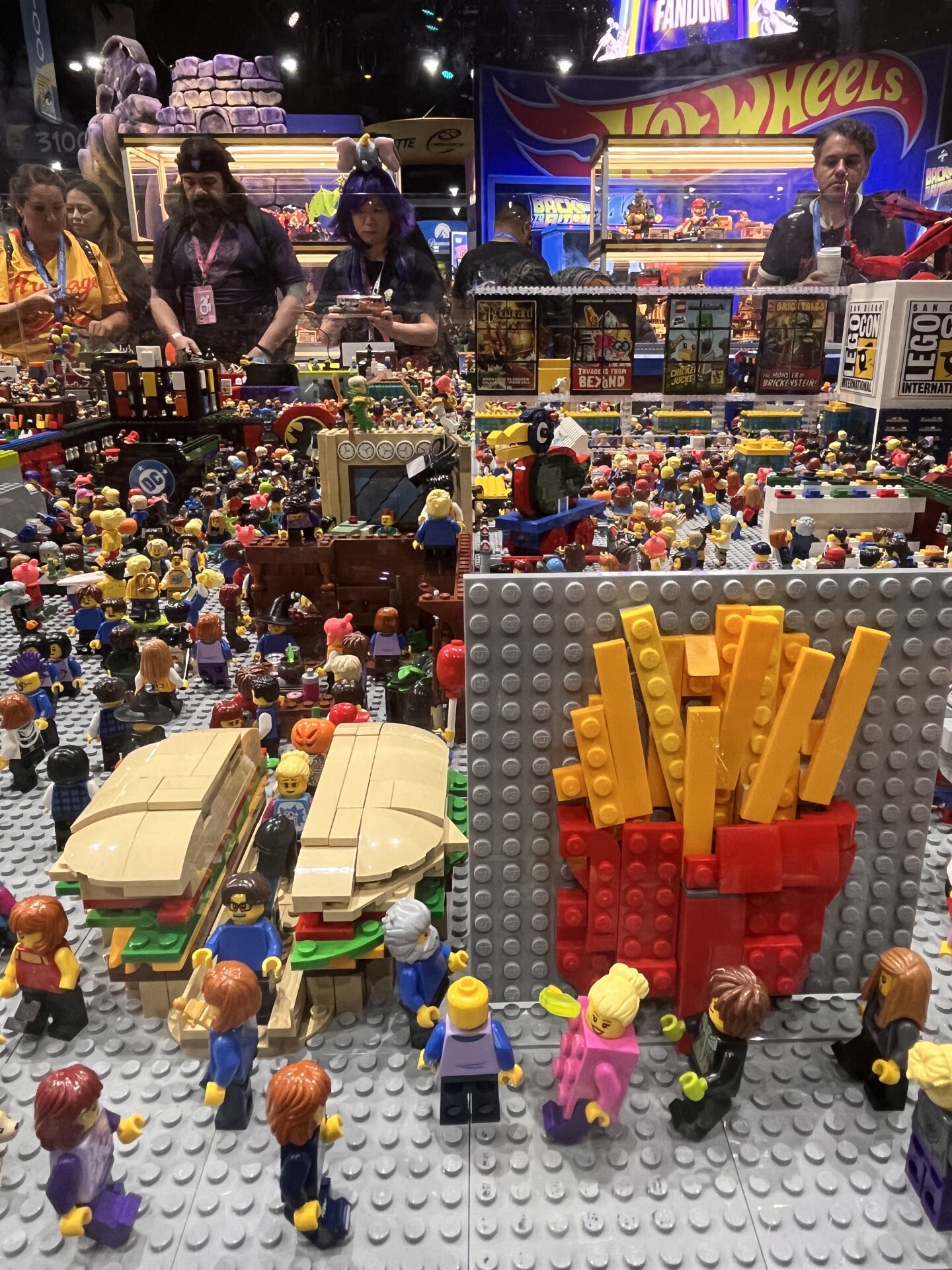 Pictured is another angle of the LEGO Comic-Con convention. LEGO figurines interact with a larger-than-life burger and fries photo opportunity.