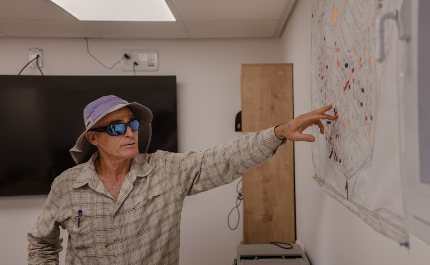 Ron Bahat, Kibbutz Nir Oz's reconstruction manager, points to a map outlining plans to rebuild the kibbutz.