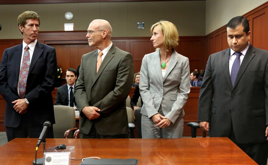 George Zimmerman, right, looks down at the moment the verdict of not guilty is read. He stands with lead defense attorney Mark O'Mara, left, defense co-counsel Don West and Lorna Truett.