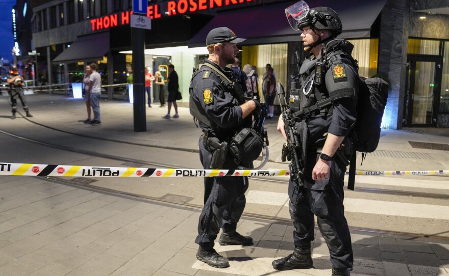 Police stand guard outside a bar in central Oslo, early Saturday, June 25, 2022. Norwegian police say people have been killed and more than a dozen injured in a mass shooting.