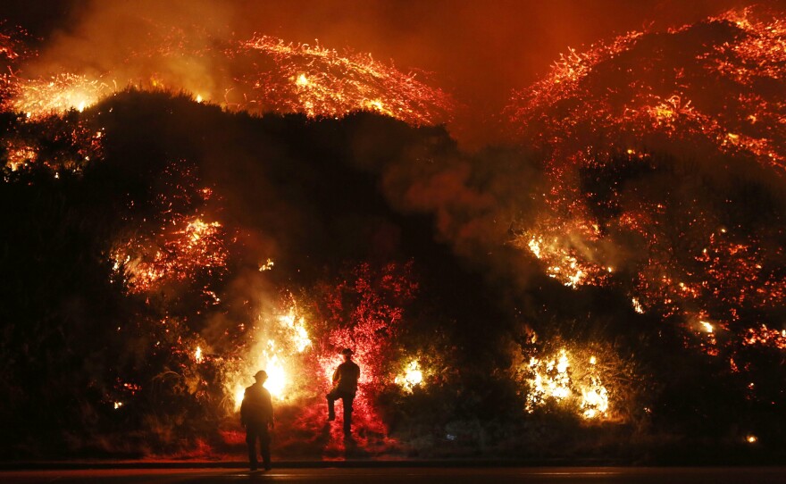 Firefighters monitor a section of the Thomas Fire along the 101 freeway, north of Ventura, Calif., on Dec. 7.