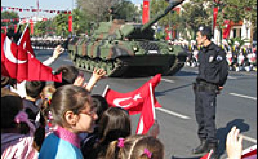Flag-waving children cheer as a parade of soldiers and tanks moves past on Turkish Republic Day. Eighty-five years after a group of army officers founded the Turkish Republic, the military still plays a major role in politics.