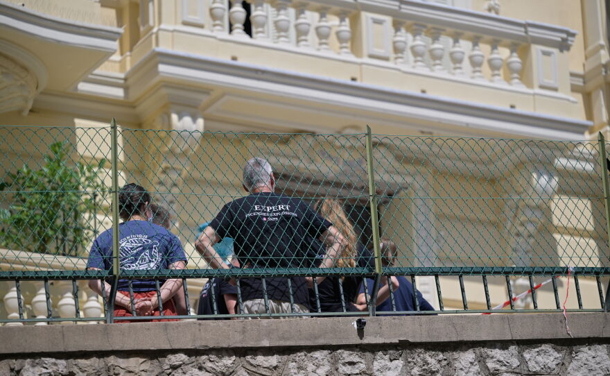 Investigators examine the scene at the residential building where an explosive device seriously injured three people a day earlier in Monaco, Tuesday, June 30, 2026.