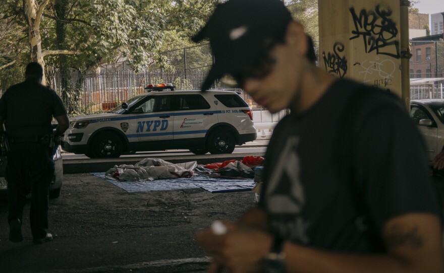 NYPD officers briefly stop by the campsite to notify residents that they will be returning in the coming days with members of a nonprofit that intends to help find them adequate shelter.