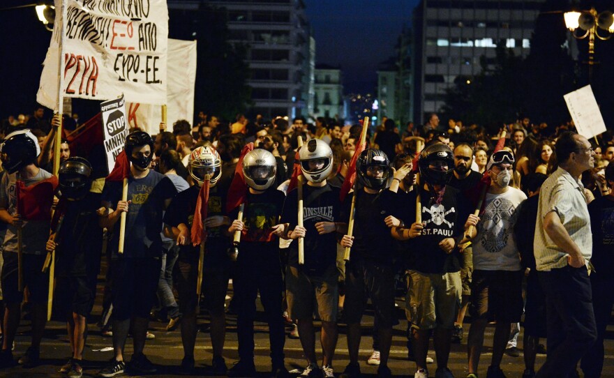 Protesters stand in front of thre Greek parliament in Athens during an anti-austerity protest on Wednesday.