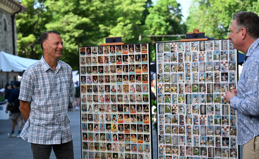 Grant Zahajko (right) appraises 1973 Topps uncut card sheets, in Baltimore, Md. ANTIQUES ROADSHOW “Maryland Zoo, Hour 2” airs Monday, April 21 at 8/7C PM on PBS.