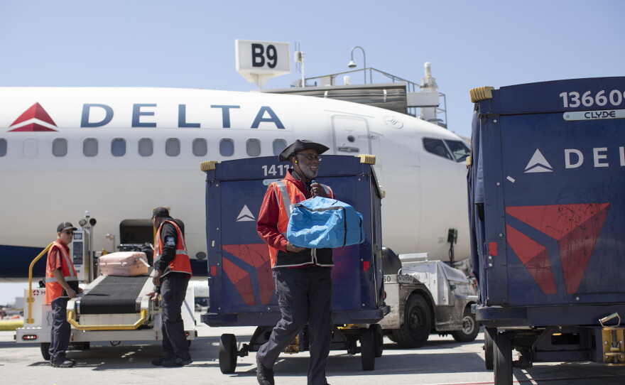 Delta Air Lines ramp agent Mike Davis prepares to load passenger luggage on his cart while working at Hartsfield-Jackson Atlanta International Airport, on May 13, 2026.