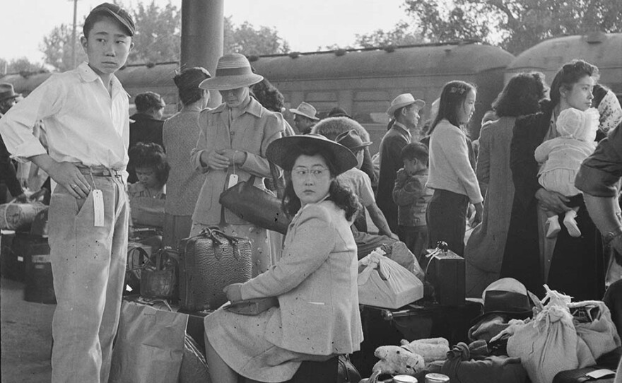 Japanese families in Woodland, California wait for a train at the station to take them to the internment camp. May 20, 1942.