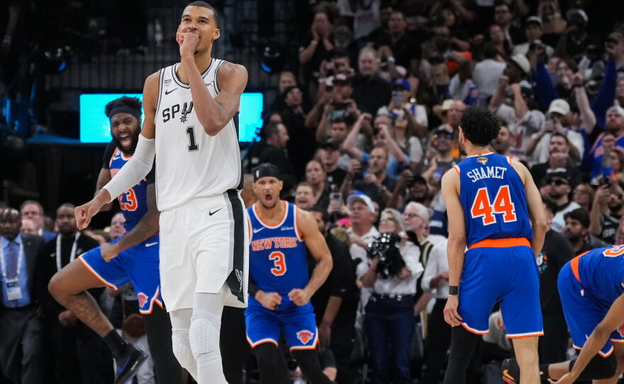 San Antonio Spurs forward Victor Wembanyama walks off the court as time expires during the second half of Game 2 of the NBA Finals basketball series as New York Knicks guard Landry Shamet (44), guard Josh Hart (3), and center Mitchell Robinson (23) celebrate, Friday, June 5, 2026, in San Antonio.