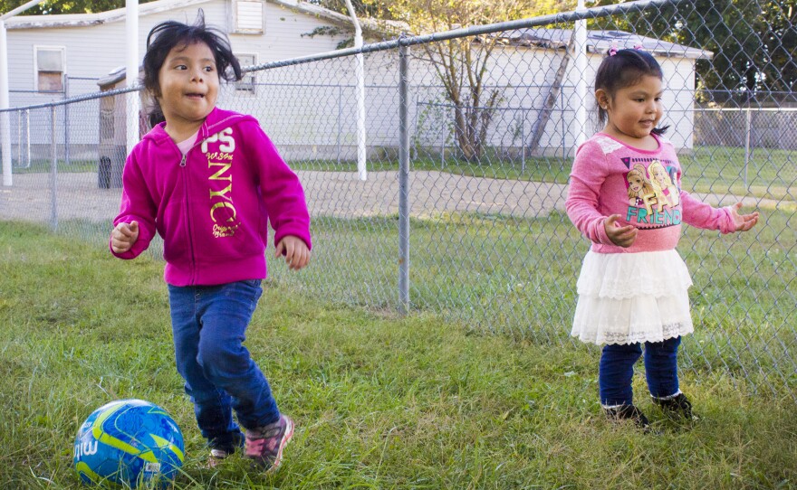 Ximena (left) kicks a soccer ball with Yareli at the Indiana Migrant Preschool Center.