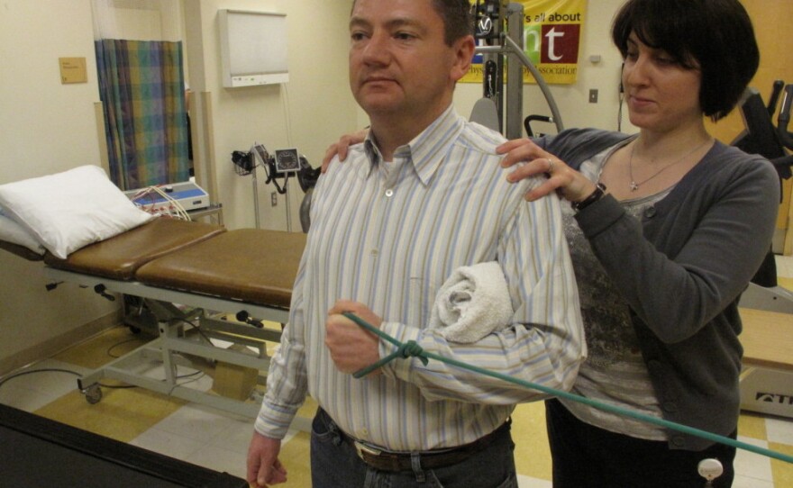Orthopedist Popi Gianakouras helps 45-year-old Bob Rothaker with physical therapy to treat his sore shoulder.