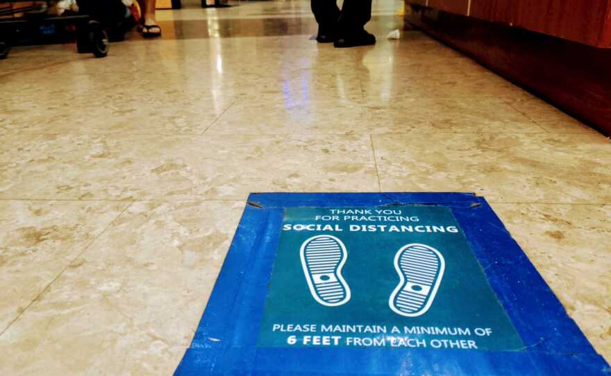 A sign taped to the floor reads "Thank you for practicing social distancing. Please maintain a minimum of 6 feet from each other" at 99 Ranch Market in Kearny Mesa. Nov. 15, 2020.