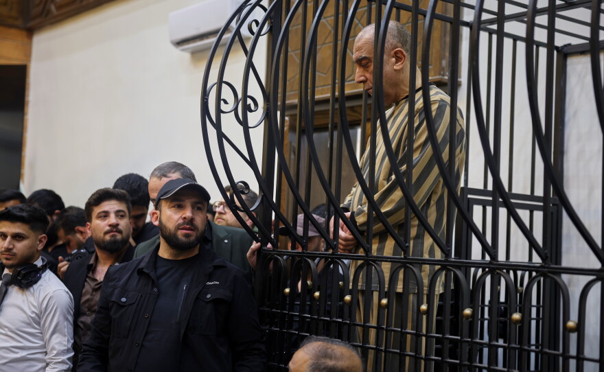 FILE -Atef Najib, former head of the Political Security Branch in the Daraa area during Bashar Assad's rule, sits in the defendants' cage during a trial session at the Palace of Justice in Damascus, Syria, April 26, 2026.