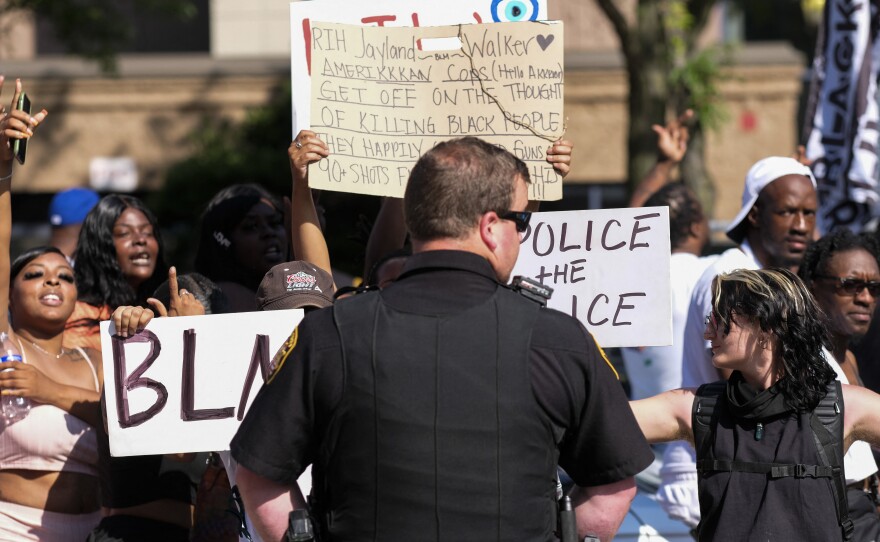 Demonstrators standoff with officers outside Akron City Hall on Sunday as they protest the fatal police shooting of Jayland Walker.