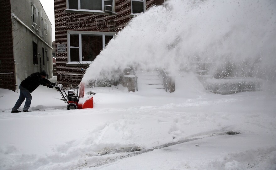 A man clears snow from a sidewalk in Brooklyn following a snow storm that left up to seven inches of snow on Friday. A major snowstorm producing blizzard-like conditions brought bone-chilling temperatures and high winds to the Northeast, with nearly 2 feet of snow falling in some areas of Massachusetts.