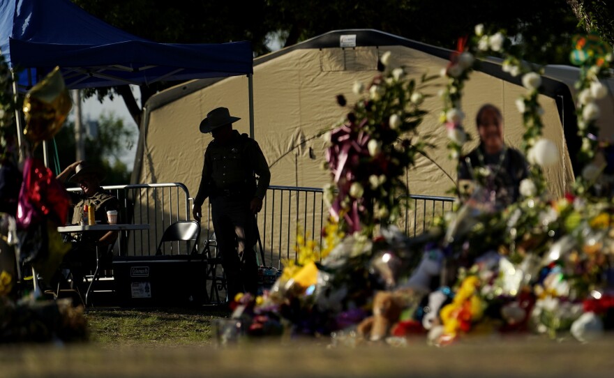A Texas Department of Public Safety officer keeps watch on June 3, 2022, in Uvalde, Texas, near a memorial outside Robb Elementary School.