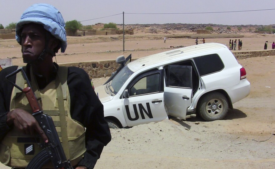A soldier of the United Nations mission to Mali stands guard near a UN vehicle after it drove over an explosive device near Kidal, northern Mali, on July 14.