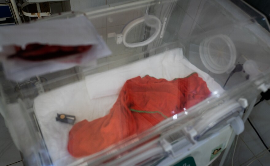 A baby born to a severely malnourished mother has died from complications. The newborn is covered with a blanket in the neonatal unit.