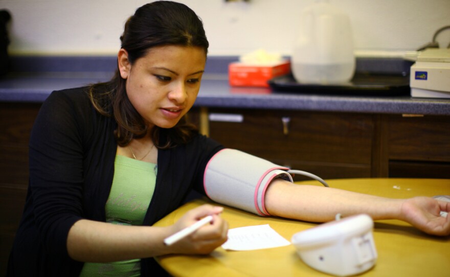 Andrea Lopez takes her own blood pressure at the group meeting. The women meet every two weeks for two hours throughout their pregnancy to learn how to monitor their own health and talk about different pregnancy-related issues.