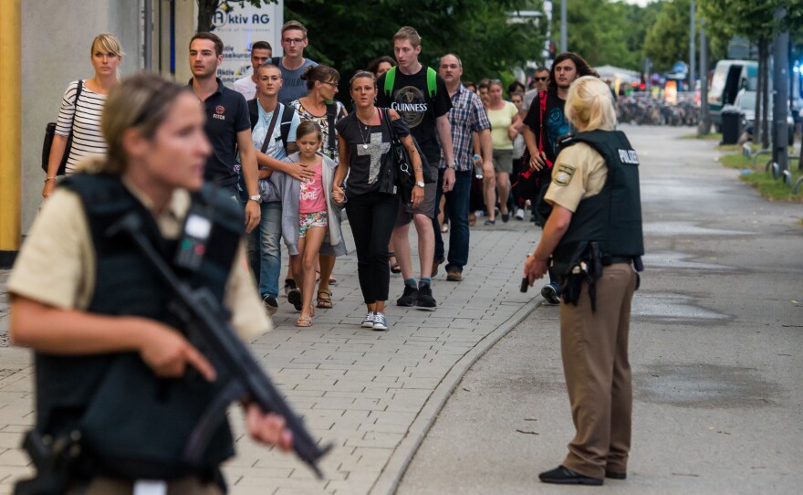 Police officers escort people from inside the shopping center as they respond to a shooting in Munich. Police believed shooters were still at large and urged residents to stay indoors.