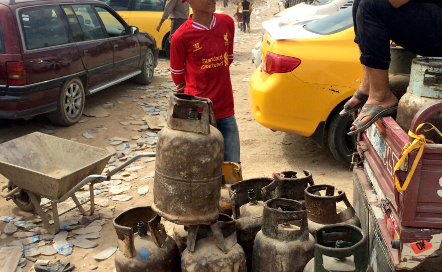 Vendors sell cooking gas to people passing in and out of the checkpoint.