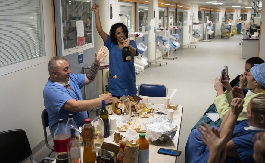 Nurse Bess Tribout, center, pops champagne to celebrate the new year in the COVID-19 intensive care unit at the la Timone hospital in Marseille, southern France, on Saturday.