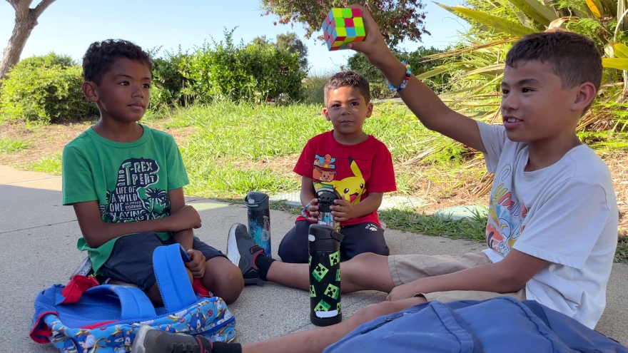 Deniece Hasson's three sons play on the sidewalk outside Marvin Elementary School, Aug. 25, 2023.