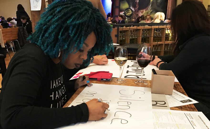 Jewel Cadet makes a protest sign for the Women's March on Washington. She is organizing a free bus ride to the march for transgender, gender non-conforming and homeless protesters from New York City.