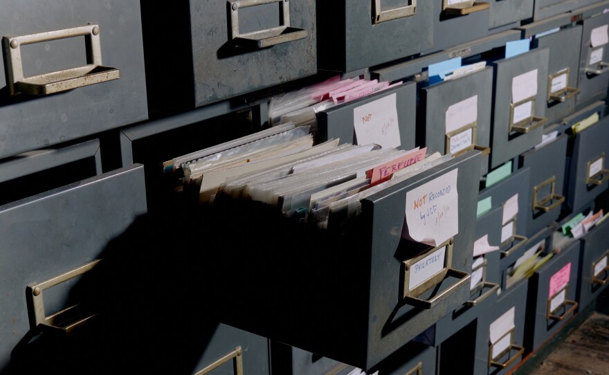 Filing cabinets organizing postcards by subject line the inside of Brown's home.