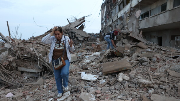 Residents walk among the rubble of building damaged in earthquakes the previous day in Catia La Mar, Venezuela